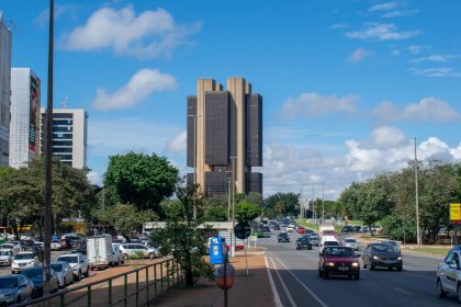 Edifício do Banco Central do Brasil em Brasília visto da rua sob um céu colorido